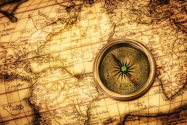 Vintage compass lies on an ancient world map. — Stock Photo, Image