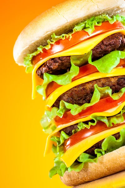 Tasty and appetizing hamburger on a yellow — Stock Photo, Image