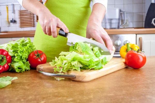 Vrouw handen snijden groenten — Stockfoto