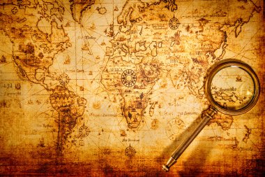 Vintage magnifying glass lies on an ancient world map clipart