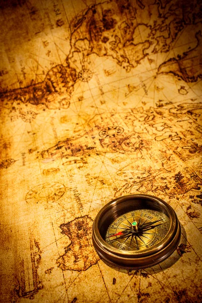 Vintage kompas ligt op een oude wereldkaart. — Stockfoto