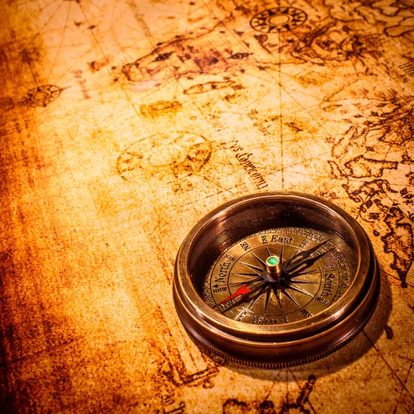 Brújula Vintage se encuentra en un mapa del mundo antiguo . — Foto de Stock