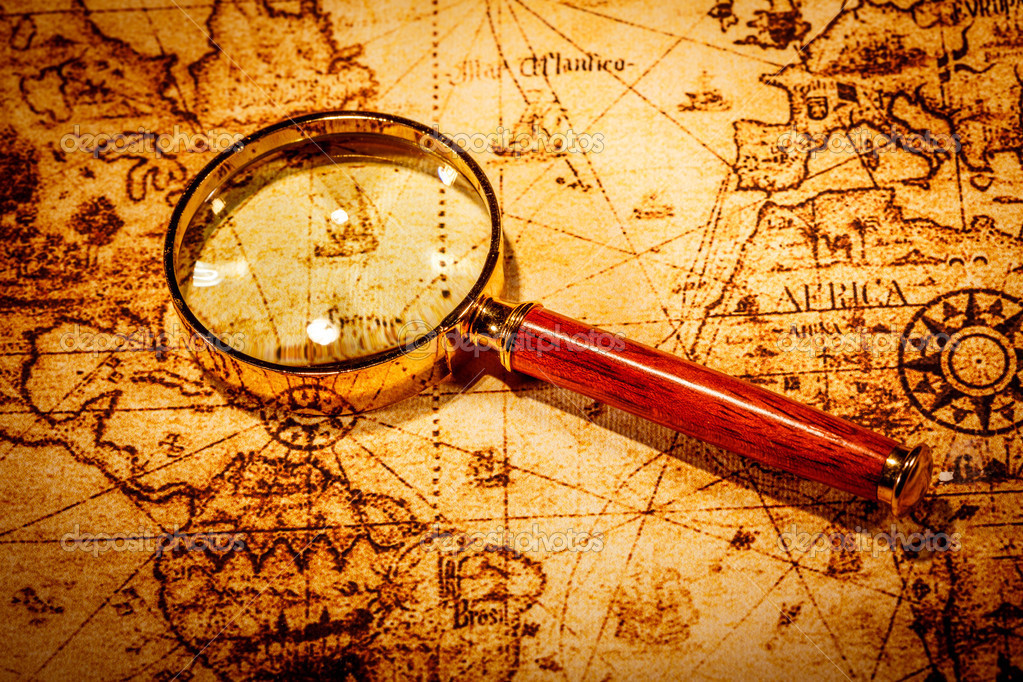 Vintage magnifying glass lies on an ancient world map — Stock Photo
