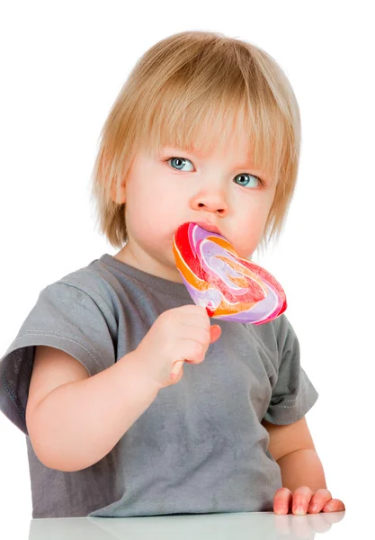 Baby eating a sticky lollipop — Stock Photo, Image
