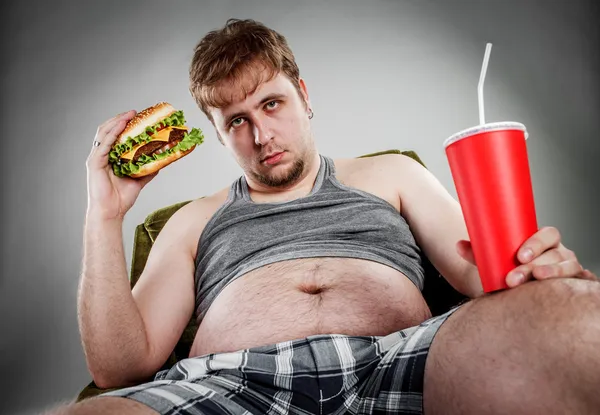 Fat man eating hamburger — Stock Photo, Image