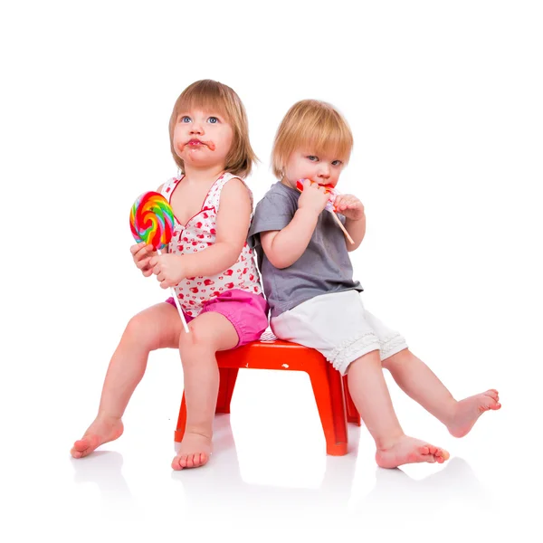 Babies eating a sticky lollipop — Stock Photo, Image