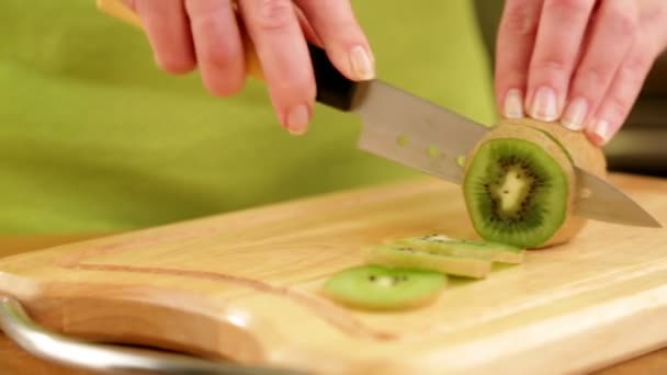 Ženské ruce bourání čerstvého kiwi v kuchyni — Stock video