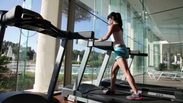 Femme courant sur tapis roulant dans la salle de gym — Video