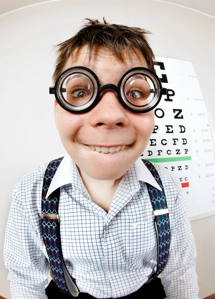 Funny boy wearing spectacles in an office at the doctor — Stock Photo, Image