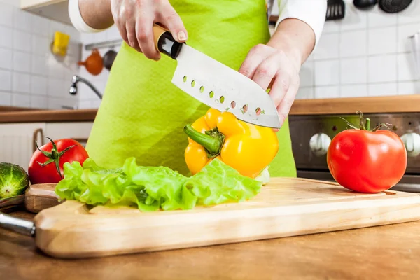 Las manos de mujer cortando verduras — Foto de Stock