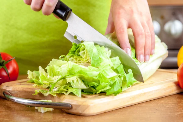 Mãos de mulher cortando legumes — Fotografia de Stock