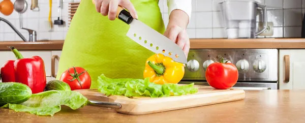 Kvinnans händer skära grönsaker — Stockfoto