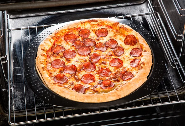 Pepperoni pizza i ugnen. — Stockfoto