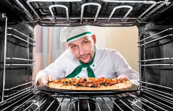 Kock matlagning pizza i ugnen. — Stockfoto