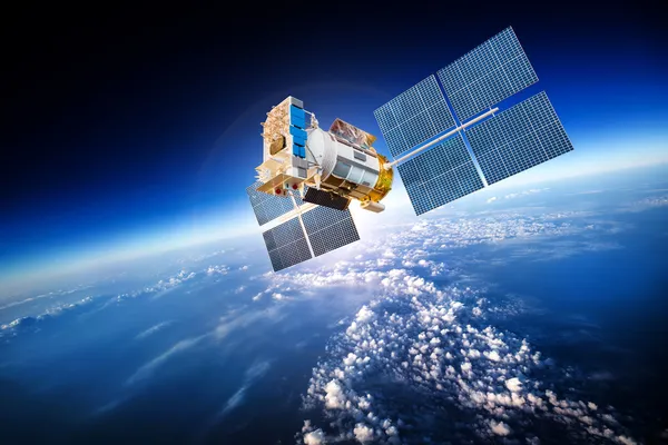 Weltraumsatellit über dem Planeten Erde lizenzfreie Stockfotos