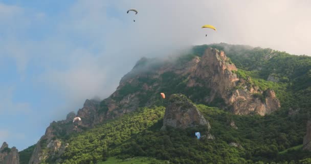 Paragliding Piloten Vliegen Paragliders Tussen Wolken Groene Bergen — Stockvideo