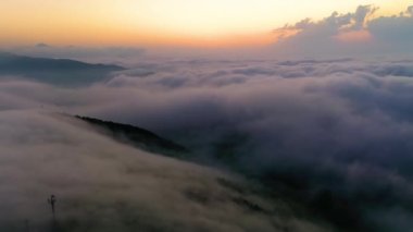Gece güneşiyle bulutların üzerinde uçuyor. Gün doğumu veya gün batımı renkli gökyüzü arkaplanı.