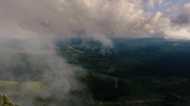 Gün batımında dağlık bir yaylanın üzerinde alçak bulutlar. Bermamyt platosunda gün batımı Kuzey Kafkasya, Karachay-Çerkessia, Rusya.