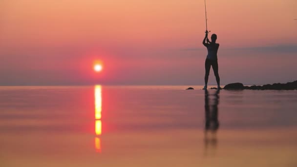 落日背景下在钓竿上钓鱼的妇女 — 图库视频影像