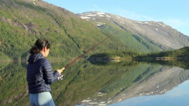 Norveç 'te balık oltasında dönen bir kadın. Norveç 'te balık tutmak yerel yaşam tarzını benimsemenin bir yoludur. Sayısız göl ve nehirler ve geniş bir kıyı şeridi olağanüstü fırsatlar demektir....