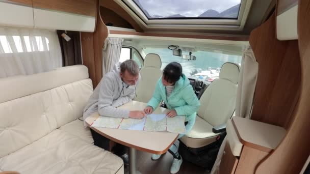 Rvキャンパーのカップルは 旅行のための地元の地図を見ています 家族旅行 休暇の旅行でMotorhome キャラバン車の休暇 — ストック動画
