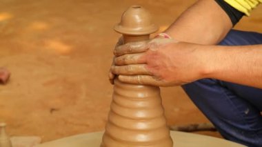Potter iş yerinde seramik yemekler yapıyor. Hindistan, Rajasthan.