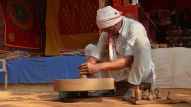 Potter iş yerinde seramik yemekler yapıyor. Hindistan, Rajasthan.