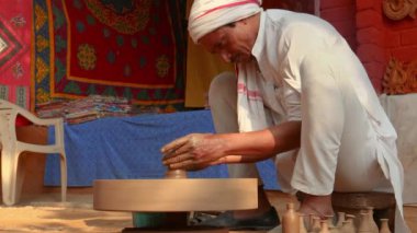 Potter iş yerinde seramik yemekler yapıyor. Hindistan, Rajasthan.