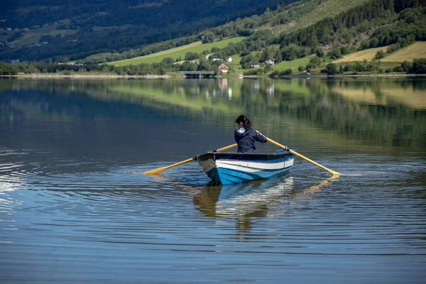 女人在船上钓鱼 美丽的自然挪威自然景观 洛达特内湖洛达尔山谷 图库照片