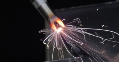 Elle tutulan lazer kaynak makinesi. Lazer kaynaklama yakın planda gösterilir.