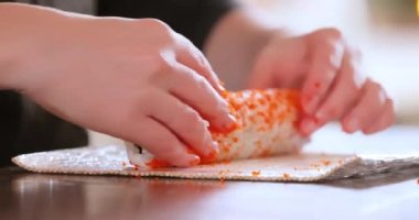 Ev Mutfağında suşi yapıyorum. Kadın eli yuvarlanan ev yapımı suşi..