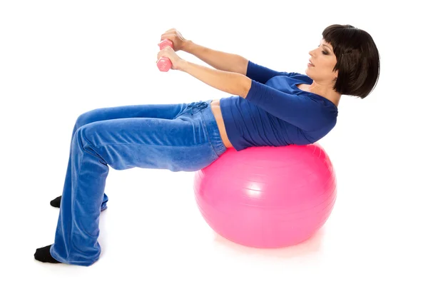 Exercises with dumbbells on a gymnastic ball — Stock Photo, Image