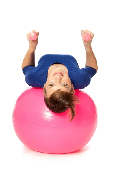 Exercícios com halteres em uma bola de ginástica — Fotografia de Stock