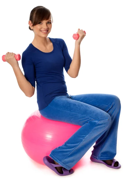 Упражнения с гантелями на гимнастическом мяче — стоковое фото