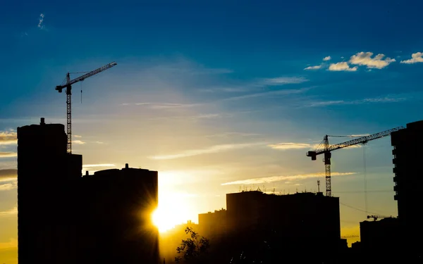 Gruas de construção e silhuetas de construção — Fotografia de Stock