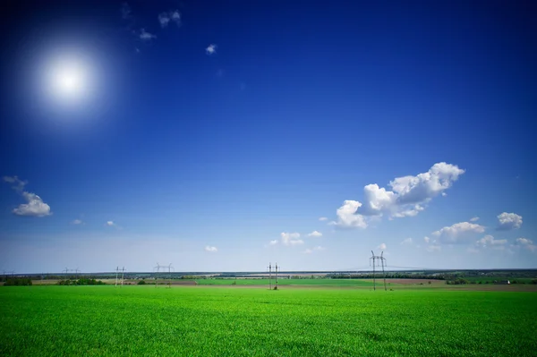 Prachtige groene veld en elektrische pylonen. — Stockfoto
