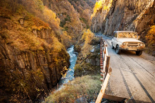 SUV เข้าสู่เทือกเขา Caucasus บนถนนภูเขา — ภาพถ่ายสต็อก