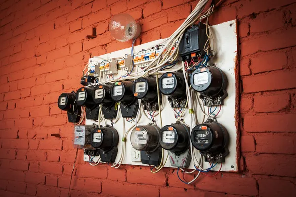 Velhos medidores elétricos em uma parede de tijolo vermelho — Fotografia de Stock