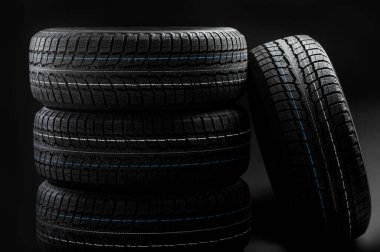 Siyah arka planda yeni kış lastikleri.