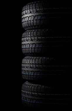 Siyah arka planda bir yığın kış lastiği, lastik dükkanı