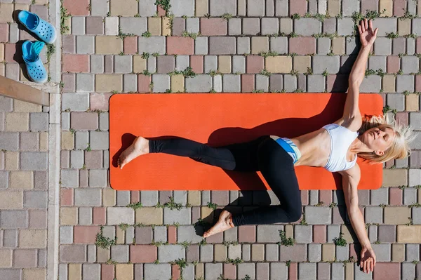 woman doing yoga outdoors, top view. Health and body