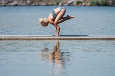 yoga exercises handstand, practicing one person by the water