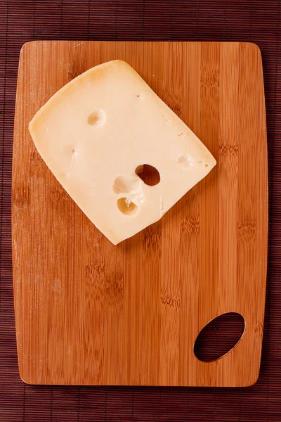 Cutting board and cheese — Stock Photo, Image