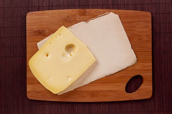 Cutting board and cheese — Stock Photo, Image