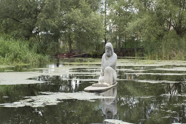 Escultura de piedra de un sacerdote en el agua —  Fotos de Stock