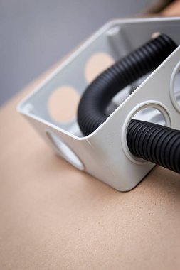 Bej arka planda kabloları olan beyaz elektrik bağlantı kutusu