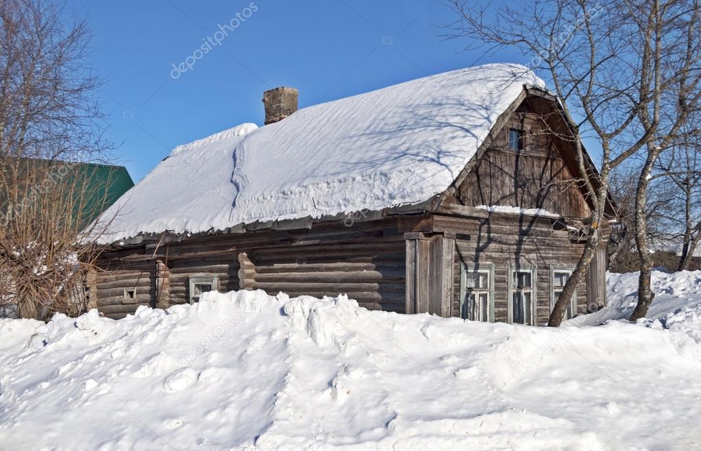 Old log hut covered with snow