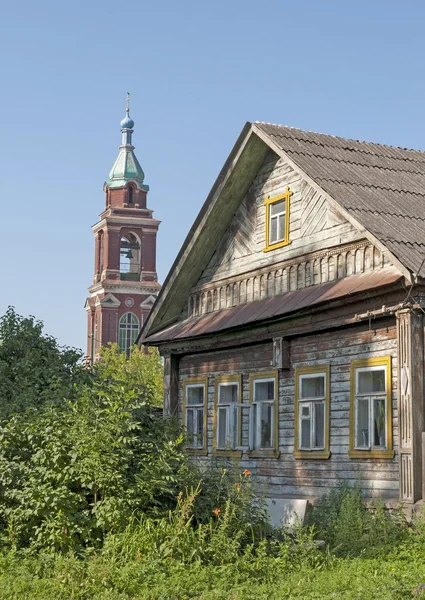 Oude houten huis en bell tower — Stockfoto