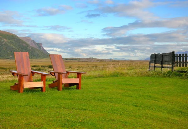 Chaises longues sur une pelouse verte sur un fond de montagnes — Photo