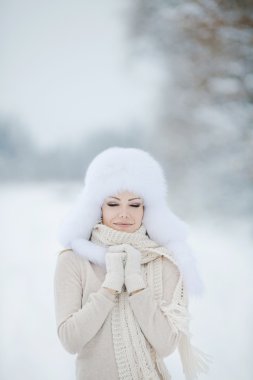 kar üzerinde kabarık beyaz şapkalı güzel kız